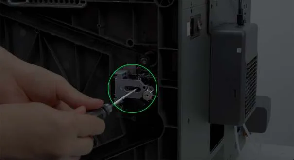 Рука послаблює натяжний гвинт осі Z шестигранним ключем, виділено зеленим колом